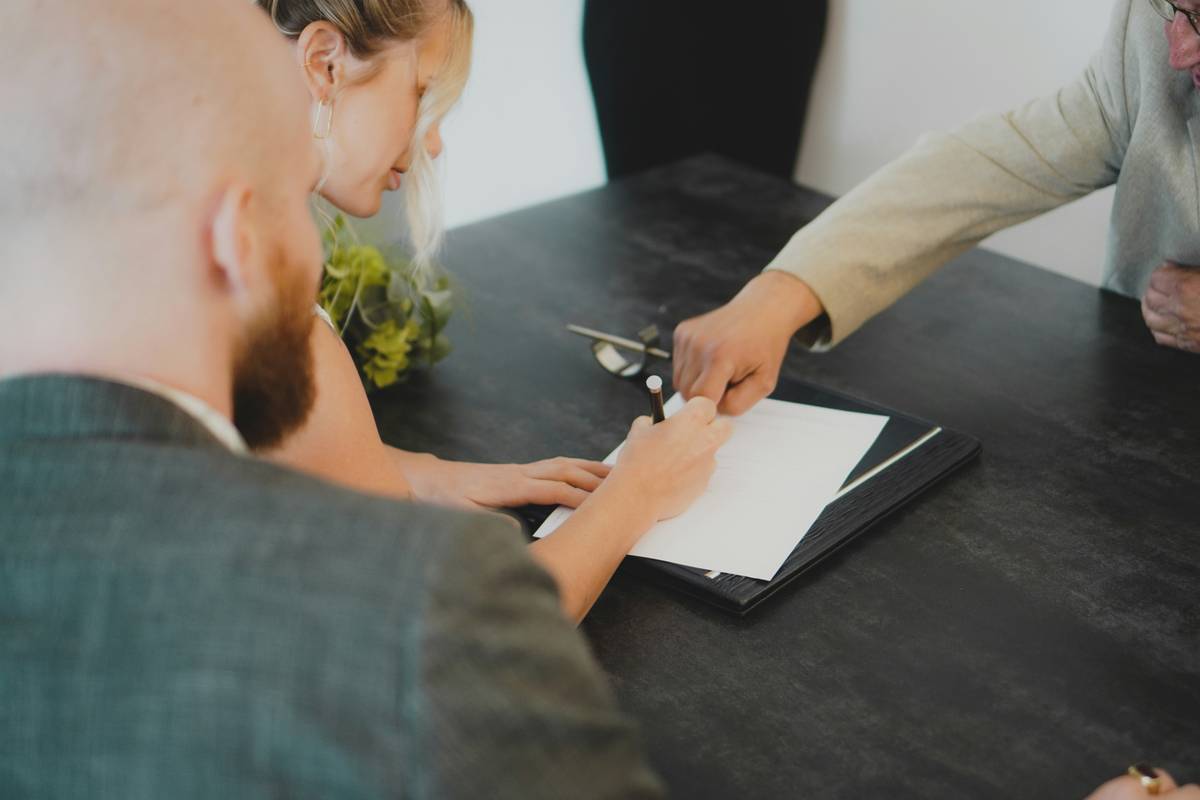 woman filling out a mutual fund withdrawal form at kitchen table with stressed expression